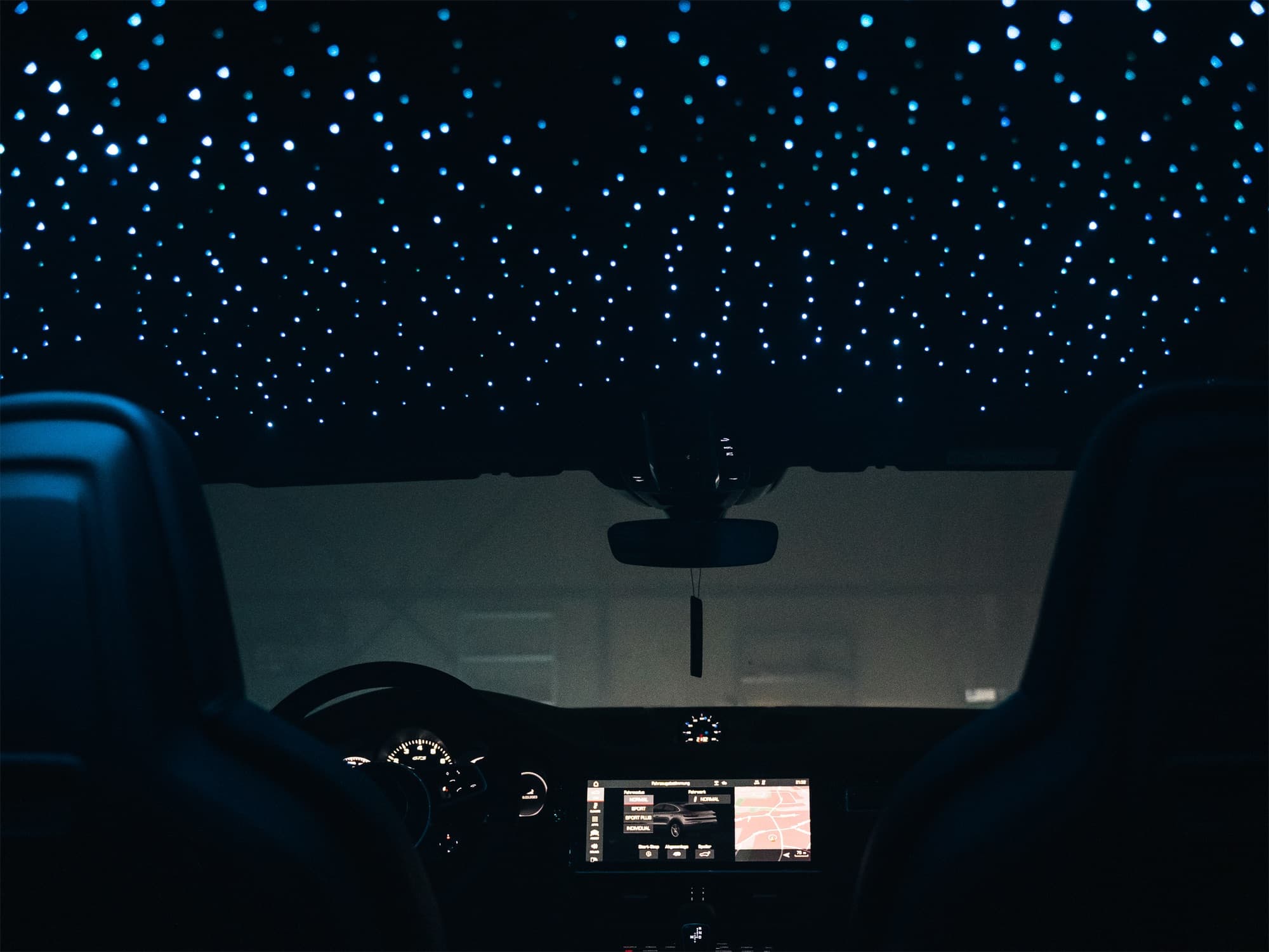 Sternenhimmel im Dachhimmel eines Porsche Cayenne Coupé, Blick von der Rückbank nach vorn